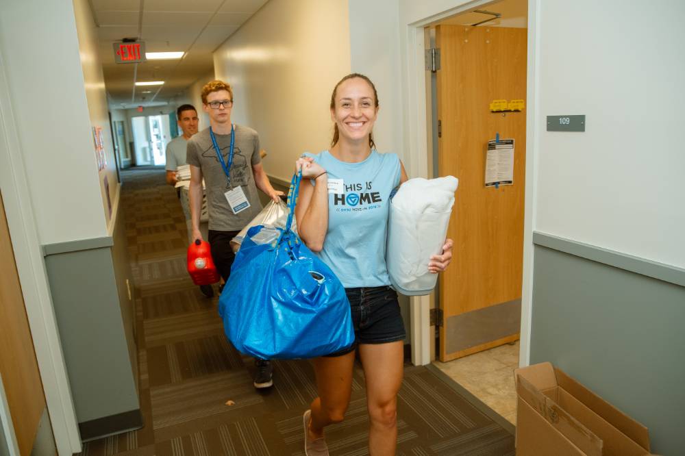 woman carries bag down hallway